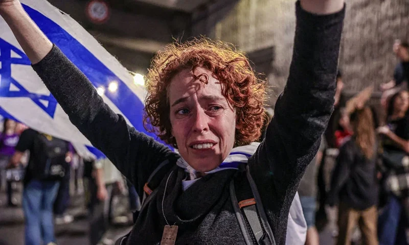 An Israeli protester cries during a large rally in Tel Aviv held by the relatives and supporters of hostages against the Prime Minister Benjamin Netanyahu's government on Monday, May 6, 2024. The angry crowd demonstrating called for the Israeli government to accept the ceasefire with Hamas in Gaza, and agree to the prisoner exchange. Hundreds of demonstrators waved Israeli flags, held banners, posters, and signs with messages calling for Netanyahu to step down. (Photo by Itai Ron / Middle East Images / Middle East Images via AFP) (Photo by ITAI RON/Middle East Images/AFP via Getty Images)
