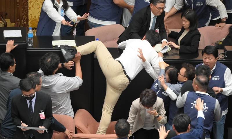 TOPSHOT-TAIWAN-POLITICS-PARLIAMENT TOPSHOT - Taiwan's ruling Democratic Progressive Party (DPP) lawmaker Kuo Kuo Wen (C) tries jumping onto the desk during the voting for the Parliament reform bill at Parliament in Taipei on May 17, 2024. (Photo by Sam Yeh / AFP) (Photo by SAM YEH/AFP via Getty Images)