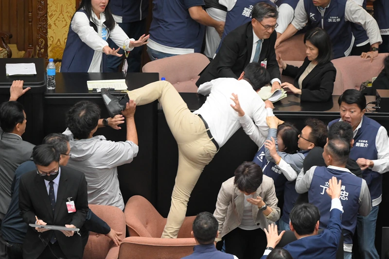 TOPSHOT-TAIWAN-POLITICS-PARLIAMENT
TOPSHOT - Taiwan's ruling Democratic Progressive Party (DPP) lawmaker Kuo Kuo Wen (C) tries jumping onto the desk during the voting for the Parliament reform bill at Parliament in Taipei on May 17, 2024. (Photo by Sam Yeh / AFP) (Photo by SAM YEH/AFP via Getty Images)