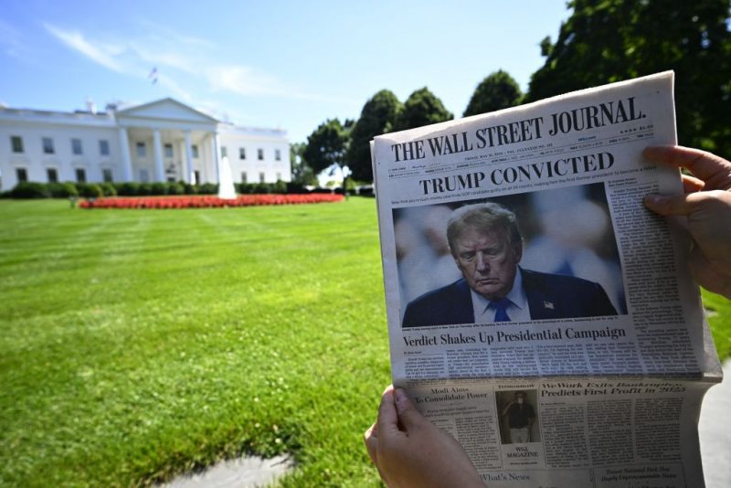 A journalist shows a 'The Wall Street Journal' newspaper with the headline reading 'Trump convicted', outside the White House in Washington DC, United States, Friday 31 May 2024.