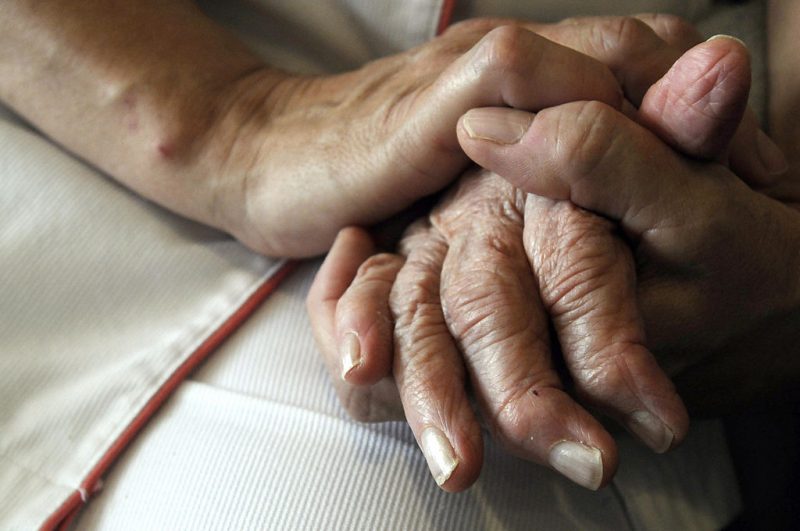 A nurse holds the hands of a person suffering from Alzheimer's disease on September 21, 2009 at Les Fontaines retirement home in Lutterbach , eastern France. Scientists working in seven countries announced last week they had uncovered variants of three genes which play a role in Alzheimer's, a discovery that should throw open many new avenues for tackling this mind-killing disease. AFP PHOTO / SEBASTIEN BOZON (Photo credit should read SEBASTIEN BOZON/AFP via Getty Images)