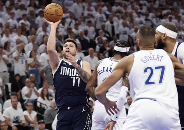 Dallas Mavericks guard Luka Doncic (77) shoots against Minnesota Timberwolves forward Jaden McDaniels (3) in the first quarter during game one of the western conference finals for the 2024 NBA playoffs at Target Center. Mandatory Credit: Jesse Johnson-USA TODAY Sports