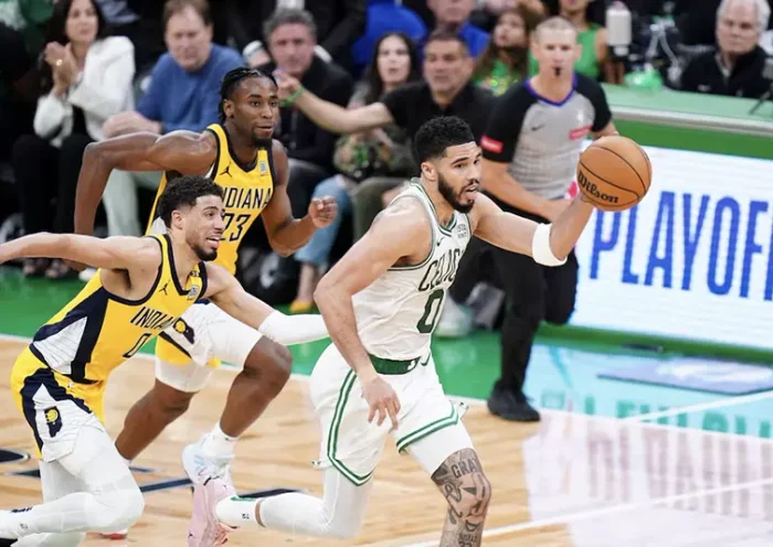 Boston Celtics forward Jayson Tatum (0) returns the ball against Indiana Pacers guard Tyrese Haliburton (0) in over-time during game one of the eastern conference finals for the 2024 NBA playoffs at TD Garden. Mandatory Credit: David Butler II-USA TODAY Sports