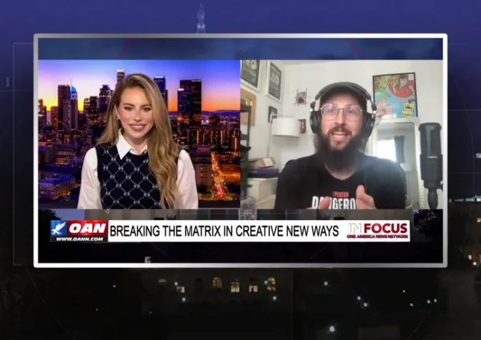 Video still from In Focus on One America News Network showing a split screen of the host on the left side, and on the right side is the guest, Hi-Rez the Rapper.