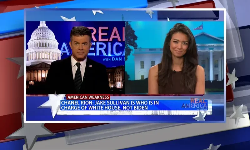 Video still from Real America on One America News Network showing a split screen of the host on the left side, and on the right side is the guest, Chanel Rion.