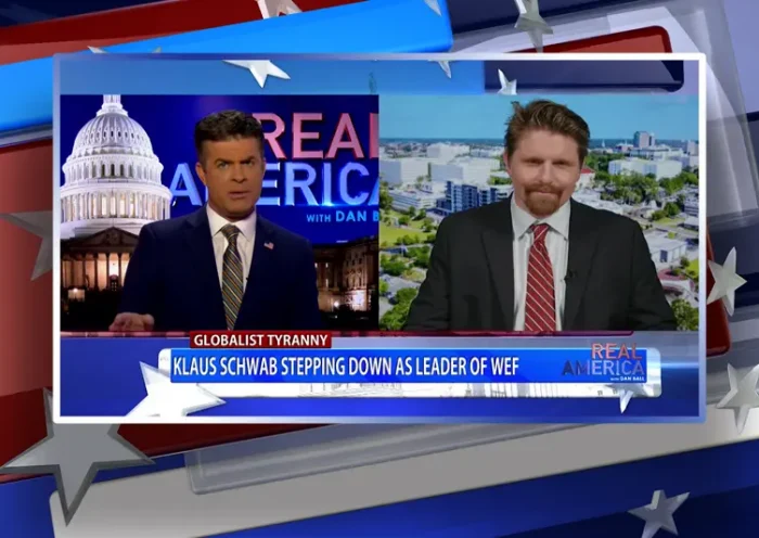 Video still from Real America on One America News Network showing a split screen of the host on the left side, and on the right side is the guest, Seamus Bruner.