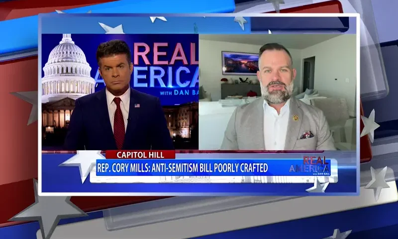 Video still from Real America on One America News Network showing a split screen of the host on the left side, and on the right side is the guest, Rep. Cory Mills.