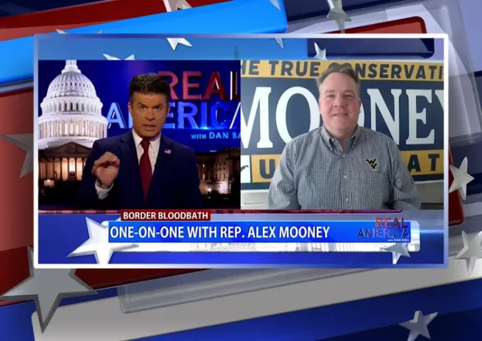 Video still from Real America on One America News Network showing a split screen of the host on the left side, and on the right side is the guest, Rep. Alex Mooney.