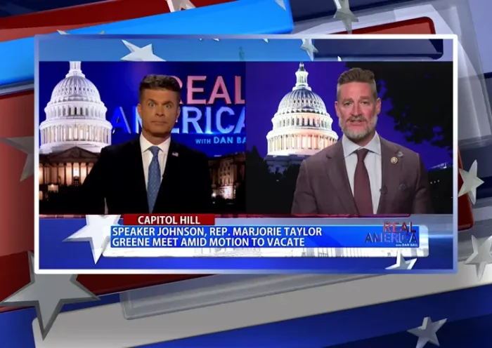 Video still from Real America on One America News Network showing a split screen of the host on the left side, and on the right side is the guest, Rep. Greg Steube.