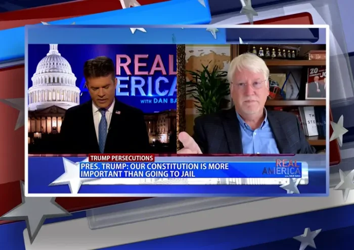 Video still from Real America on One America News Network showing a split screen of the host on the left side, and on the right side is the guest, Joe Hoft.