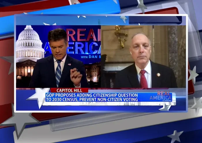 Video still from Real America on One America News Network showing a split screen of the host on the left side, and on the right side is the guest, Rep. Andy Biggs.