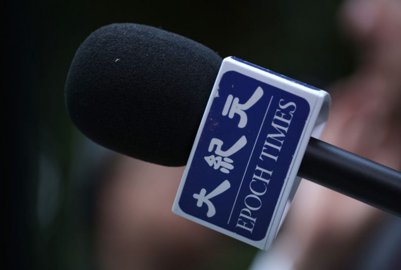 BERLIN GERMANY - OCTOBER 23: A reporter for The Epoch Times holds a microphone during a media event on October 23, 2023 in Berlin, Germany. The Epoch Times is owned by Epoch Media Group and is affiliated with the Falun Gong movement. (Photo by Sean Gallup/Getty Images)