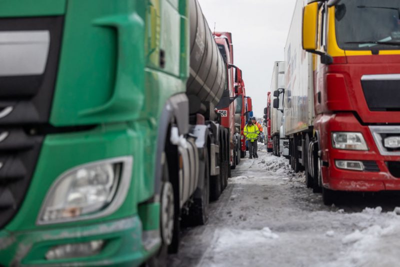 Ukrainian truck drivers are seen next to Ukrainian trucks on the parking lot near Korczowa Polish-Ukrainian border crossing, on December 5, 2023. In a Polish car park near the Ukrainian border, truck drivers stranded by a month-long blockade that has caused disruption and a row with Ukraine shoveled snow off their vehicles.
