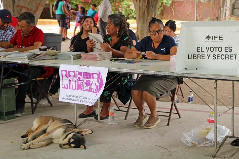 MEXICO-ELECTION-VOTE
Election staff members wait for voters at a polling station during the general election in Tlacolula de Matamoros, state of Oaxaca, Mexico, on June 2, 2024. Mexicans voted Sunday in a presidential election dominated by two women -- a historic first in a country plagued by rampant criminal and gender-based violence. (Photo by PATRICIA CASTELLANOS / AFP) (Photo by PATRICIA CASTELLANOS/AFP via Getty Images)
